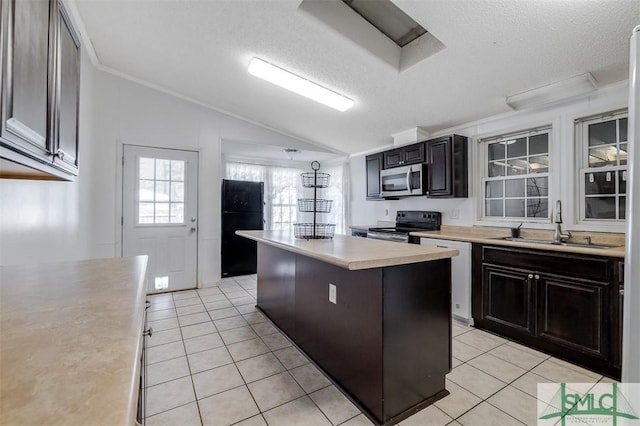 kitchen with stainless steel appliances, light tile patterned flooring, a sink, and light countertops