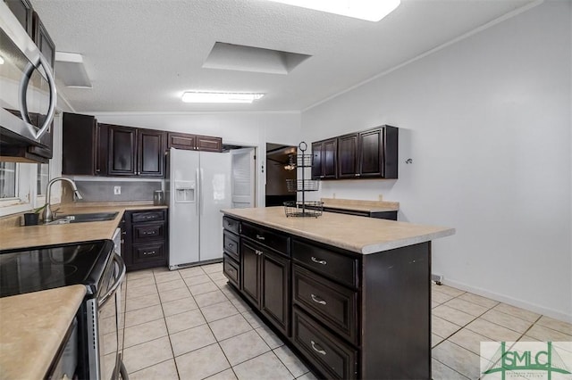 kitchen featuring stainless steel appliances, lofted ceiling, light countertops, and light tile patterned floors