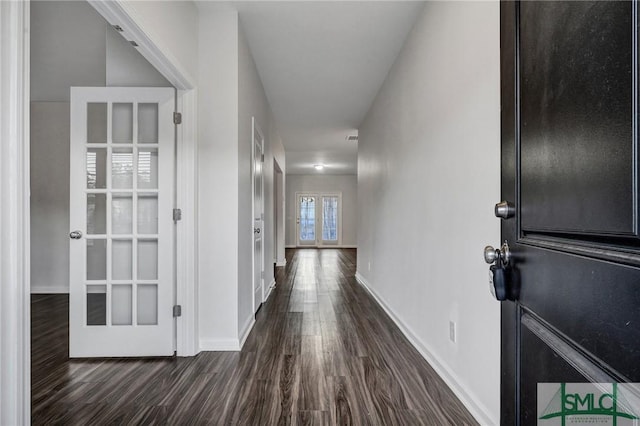 corridor with dark wood-style floors, french doors, and baseboards