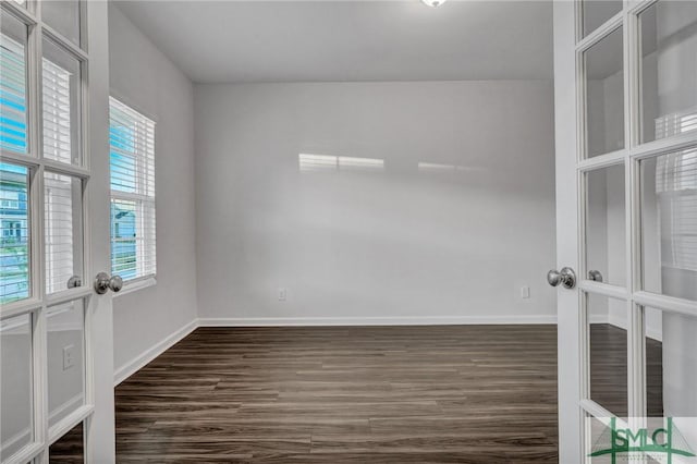 unfurnished room with french doors, dark wood finished floors, and baseboards