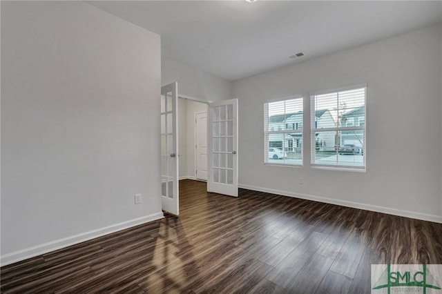 unfurnished bedroom with french doors, visible vents, dark wood finished floors, and baseboards