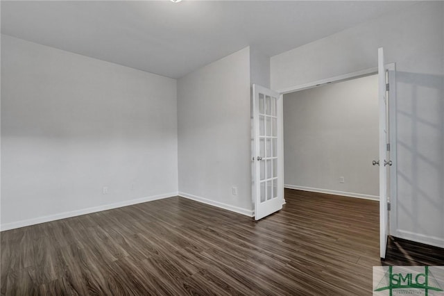 empty room featuring dark wood-style flooring, french doors, and baseboards