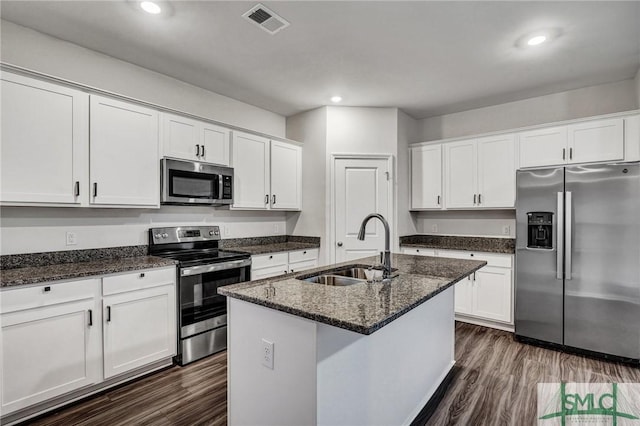 kitchen featuring stainless steel appliances, dark wood-style flooring, a sink, visible vents, and white cabinets