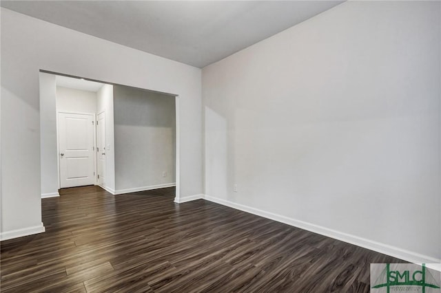 unfurnished bedroom featuring baseboards and dark wood-type flooring