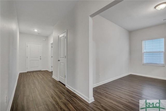 hallway with dark wood finished floors and baseboards