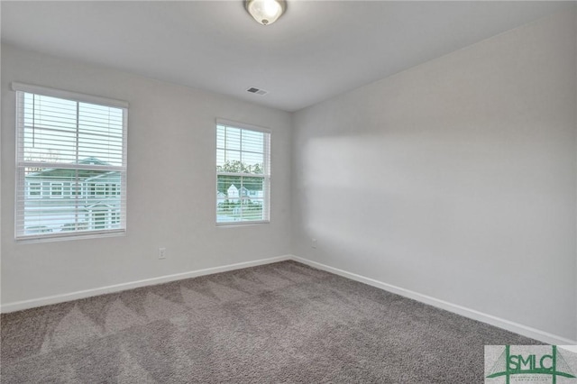 carpeted empty room featuring baseboards