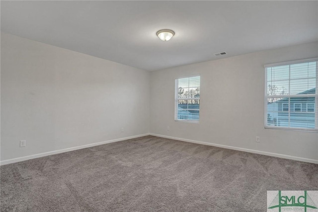 carpeted spare room featuring visible vents and baseboards