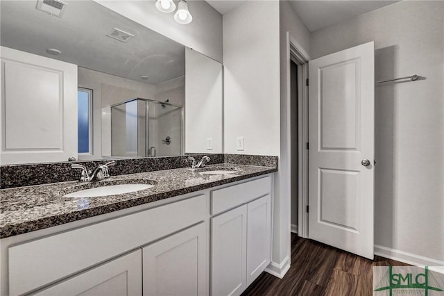 bathroom featuring visible vents, a sink, and a shower stall