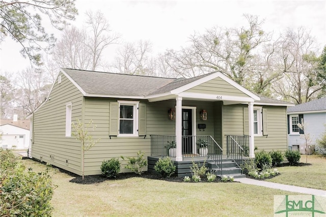 bungalow featuring roof with shingles, a porch, and a front lawn