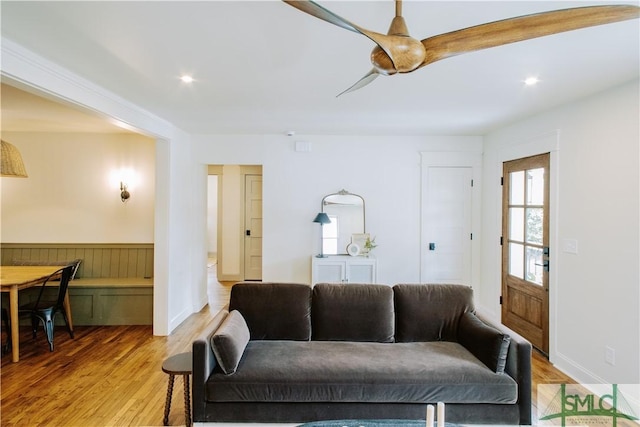 living area featuring light wood finished floors, wainscoting, and recessed lighting