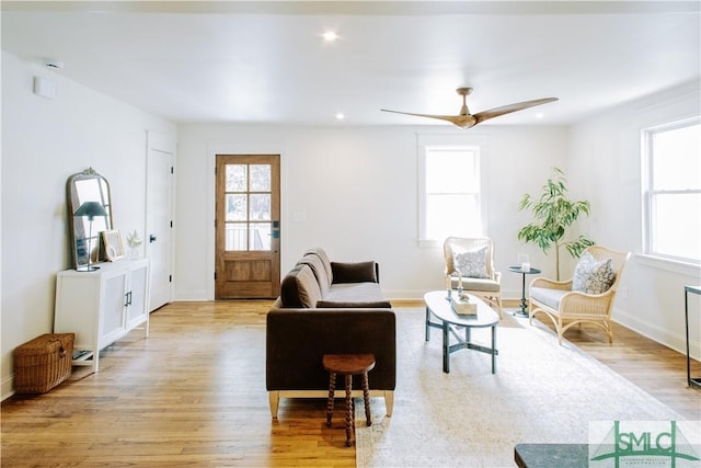 living room featuring baseboards, a ceiling fan, light wood-style flooring, and recessed lighting