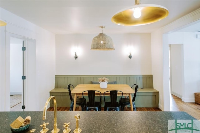 dining room with wainscoting and wood finished floors