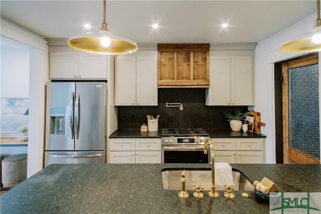 kitchen with pendant lighting, backsplash, appliances with stainless steel finishes, white cabinetry, and a sink