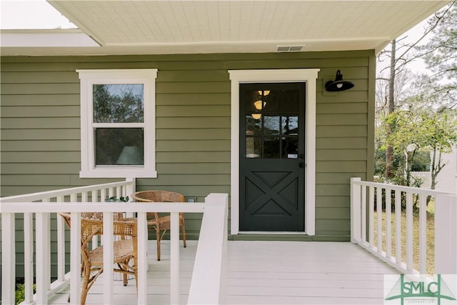 property entrance featuring a porch and visible vents