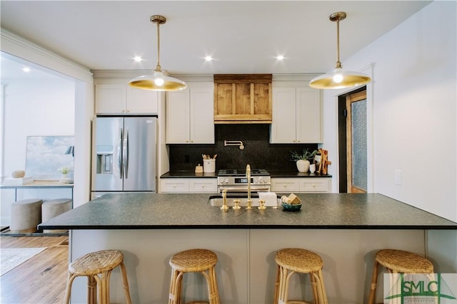 kitchen featuring dark countertops, white cabinetry, tasteful backsplash, and appliances with stainless steel finishes