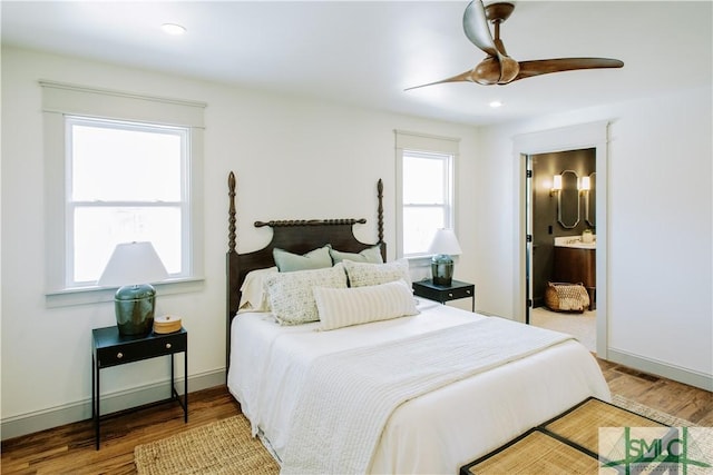 bedroom featuring recessed lighting, baseboards, wood finished floors, and ensuite bathroom