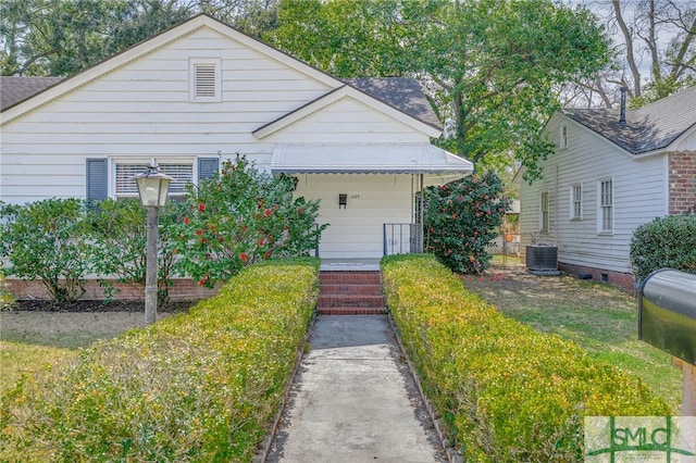 bungalow-style house featuring covered porch, central AC unit, and roof with shingles