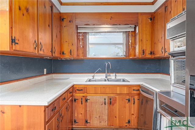 kitchen featuring dishwasher, light countertops, a sink, and brown cabinetry