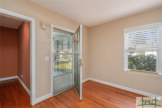 foyer featuring baseboards and wood finished floors