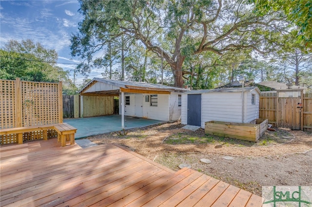 exterior space featuring a carport, an outdoor structure, a storage unit, and fence