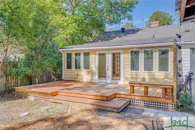 back of house with a shingled roof, fence, french doors, a wooden deck, and a chimney