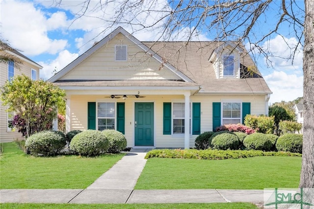 view of front of house with ceiling fan and a front yard