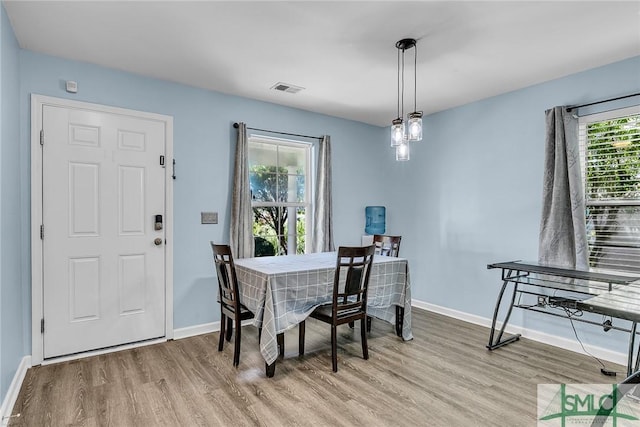 dining room with visible vents, baseboards, and wood finished floors