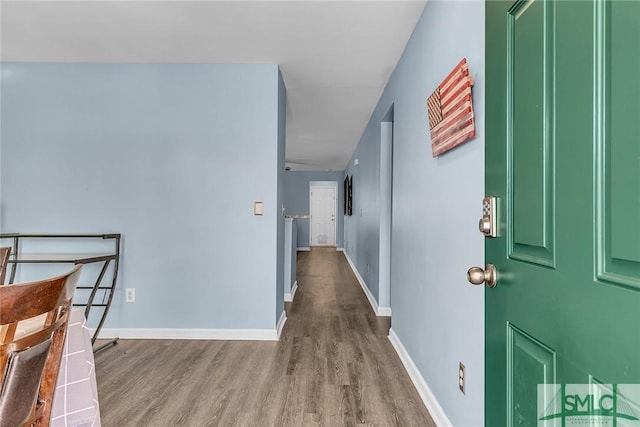 hallway with baseboards and wood finished floors