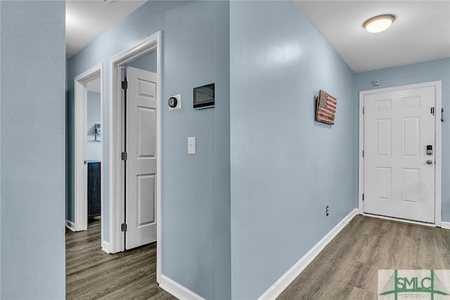 hall with baseboards and wood finished floors