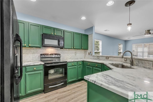 kitchen featuring green cabinets, black appliances, and a sink