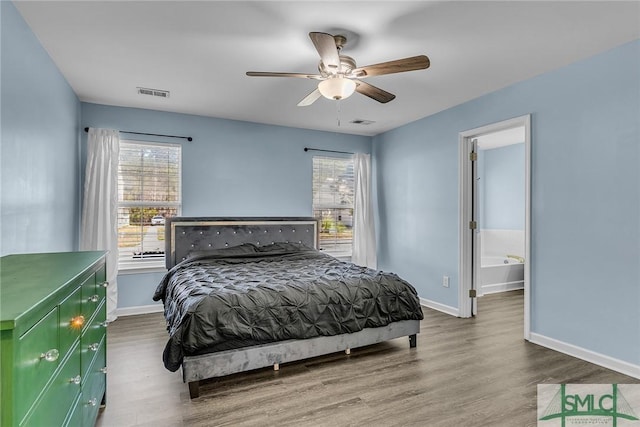 bedroom featuring visible vents, multiple windows, and wood finished floors