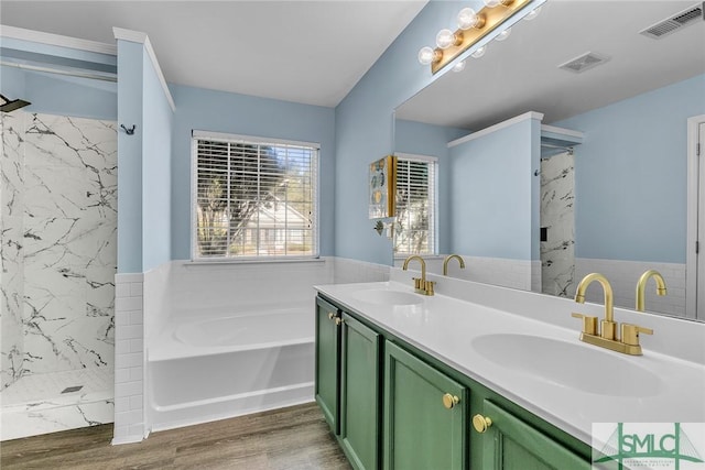 full bath with a marble finish shower, wood finished floors, a garden tub, and a sink