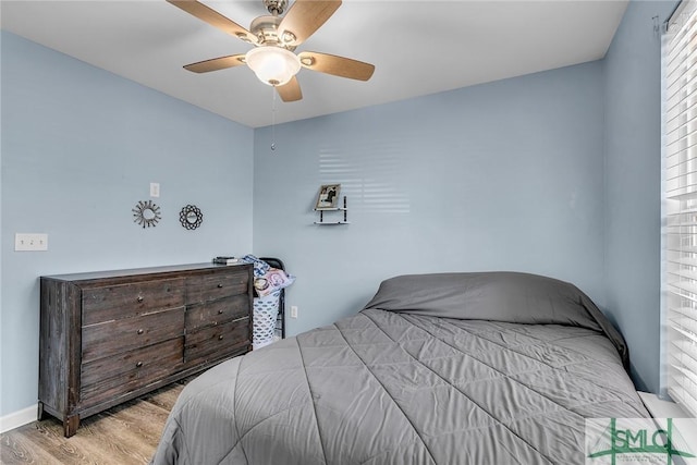 bedroom featuring wood finished floors, baseboards, and ceiling fan