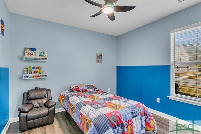 bedroom with a ceiling fan, wood finished floors, and baseboards