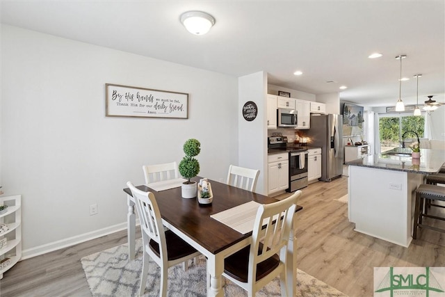 dining area featuring light wood-style floors, baseboards, and recessed lighting