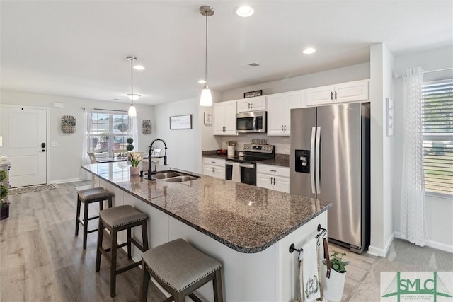 kitchen with stainless steel appliances, plenty of natural light, a sink, and white cabinets