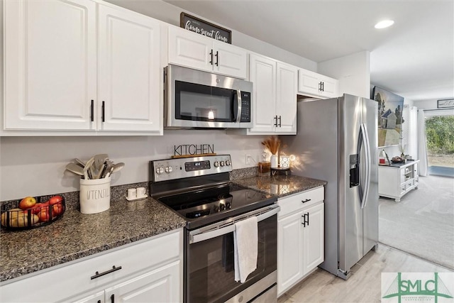 kitchen featuring appliances with stainless steel finishes, recessed lighting, white cabinets, and dark stone countertops