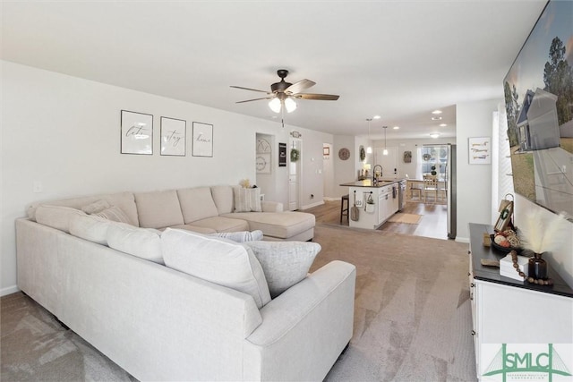 living room featuring a ceiling fan and baseboards