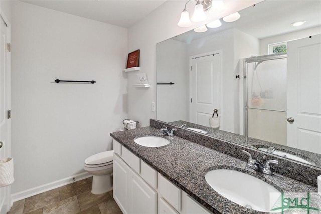 full bathroom featuring a sink, a shower stall, and toilet