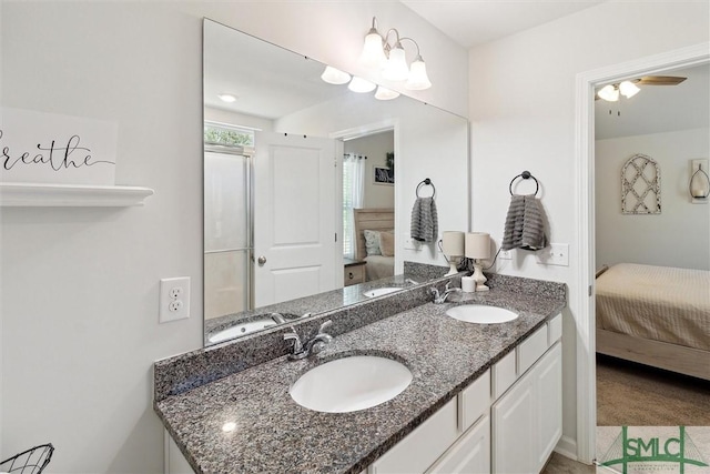 ensuite bathroom with a sink, double vanity, ceiling fan, and ensuite bath