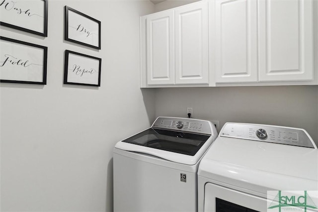 washroom featuring cabinet space and washing machine and clothes dryer