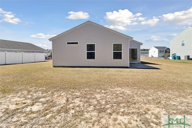 back of house with fence and a lawn