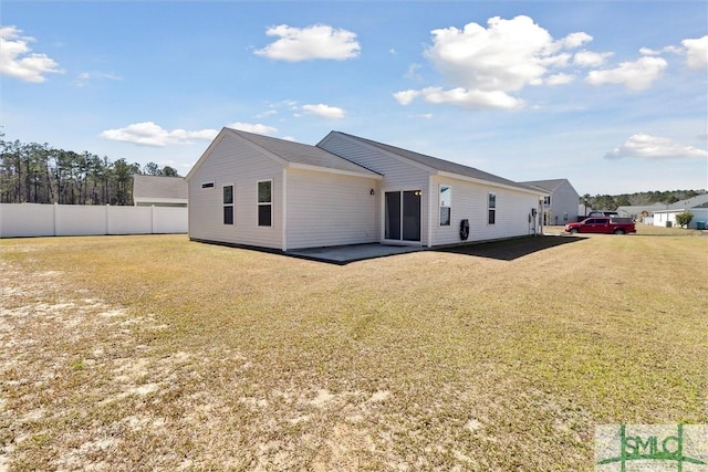 rear view of property with a yard and fence