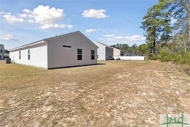 view of side of property featuring cooling unit and a yard