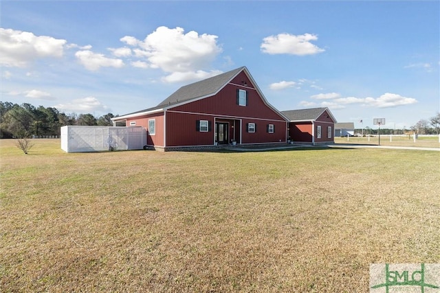 view of front facade featuring a barn, a front lawn, and an outbuilding