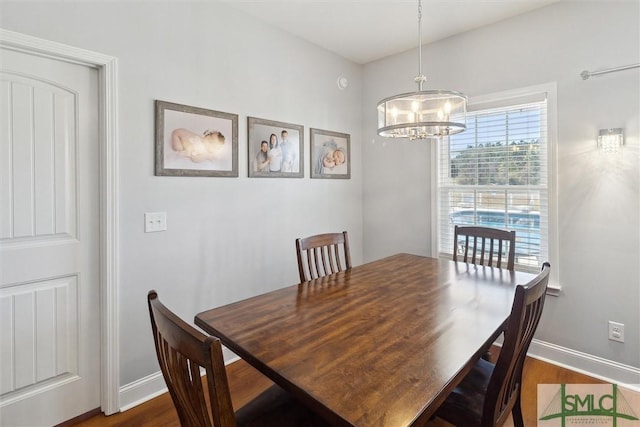 dining room with dark wood finished floors, baseboards, and an inviting chandelier