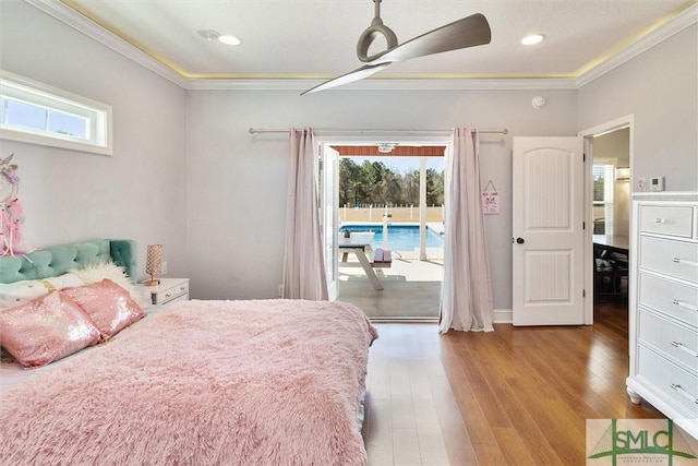 bedroom with ornamental molding, multiple windows, wood finished floors, and access to exterior