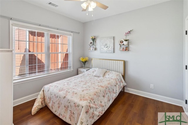 bedroom featuring a ceiling fan, visible vents, baseboards, and wood finished floors