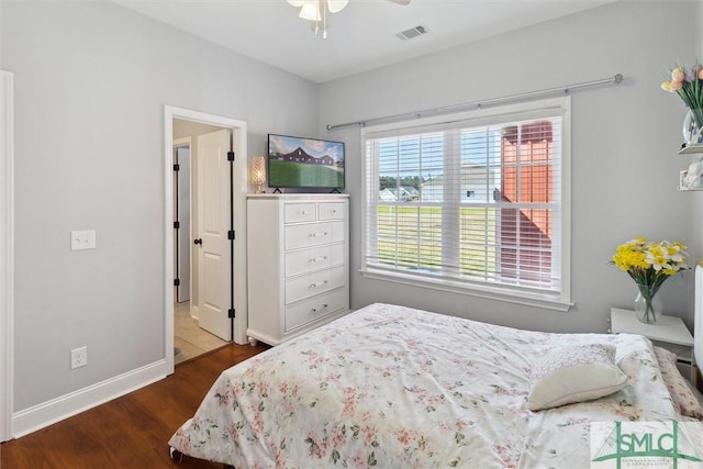 bedroom with a ceiling fan, visible vents, dark wood finished floors, and baseboards