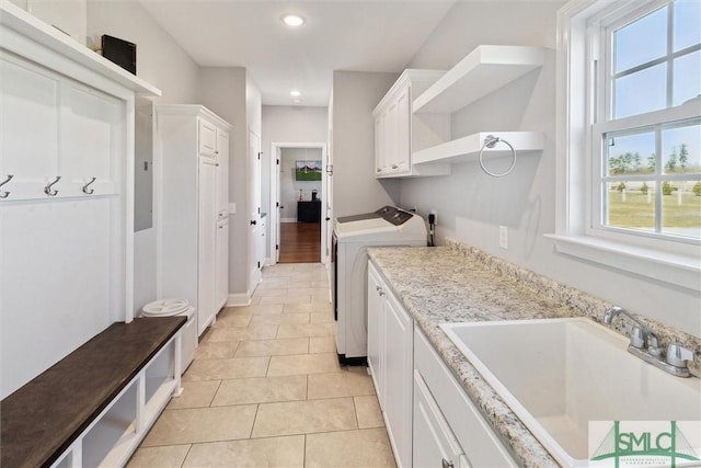 interior space featuring light tile patterned floors, white cabinets, independent washer and dryer, open shelves, and a sink